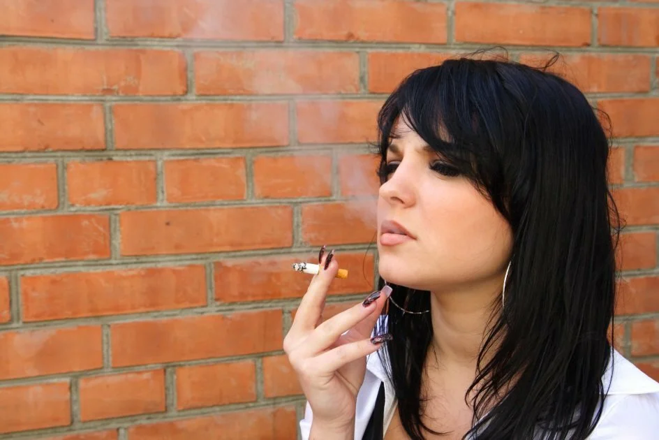 young woman smoking outside