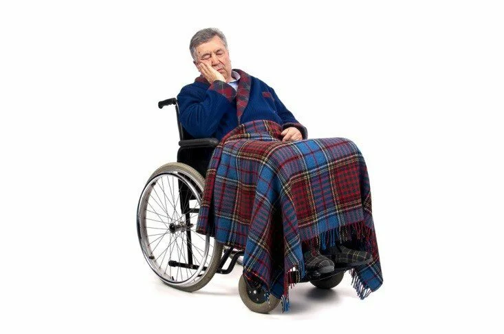 Man covered up and sleeping in wheel chair CanadianPharmacyMeds.com