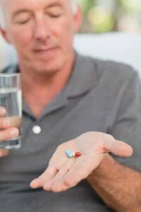 Man about to take his medication CanadianPharmacyMeds.com