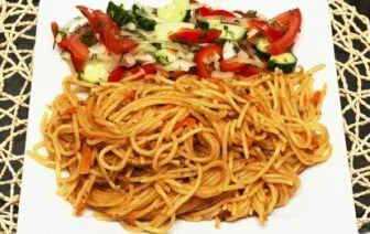 Tomatoa pasta on plate with fresh basil leaves