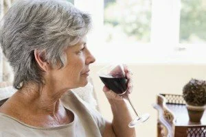 Woman having small glass of wine CanadianPharmacyMeds.com